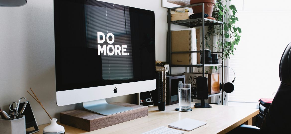 a computer sitting on a home office desk; the monitor says, Do More. Do More with a nonprofit fractional COO!